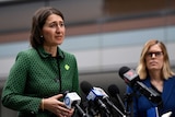 Gladys Berejiklian addresses the media as Dr Kerry Chant stands in the background.
