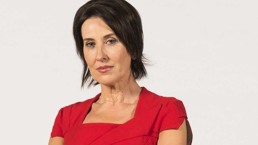 Virginia Trioli stands with her arms crossed looking at the camera.