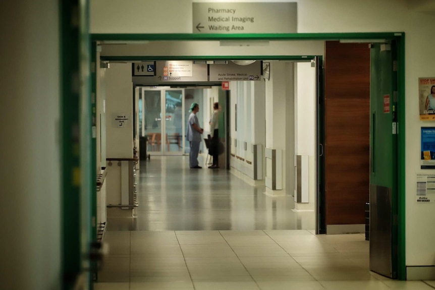 Couloir de l'hôpital avec deux membres du personnel médical debout au loin à l'hôpital de la base Mackay.