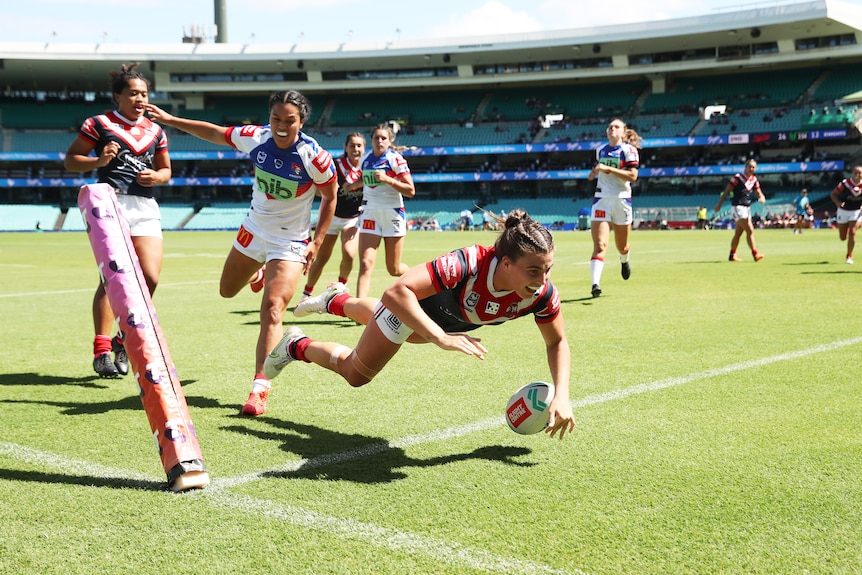 A woman runs in to score during an NRLW match 