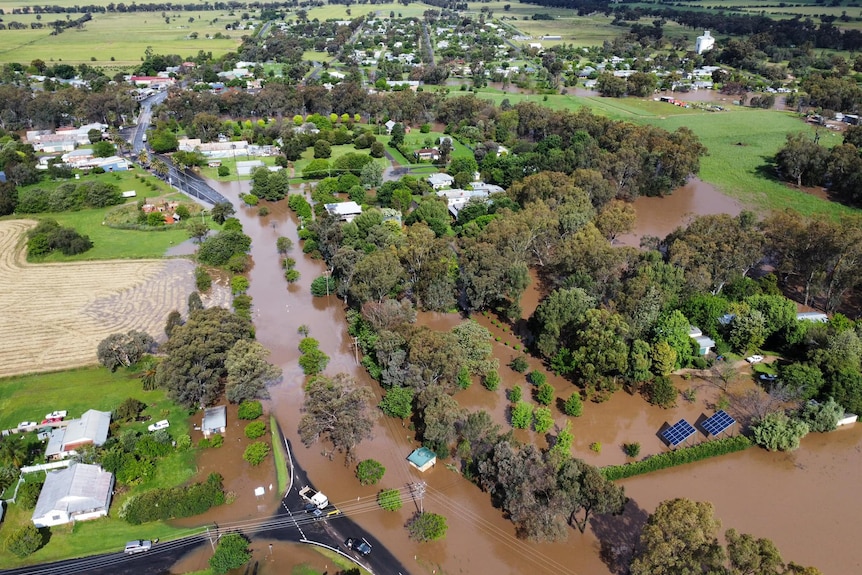 An aerial shot of a small town covered in brown water.