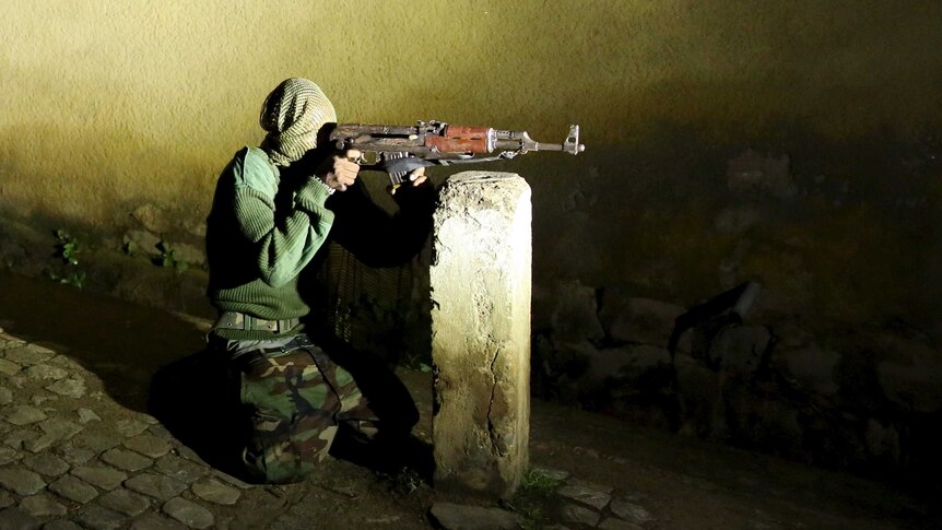 An armed vigilante holds an AK-47 rifle in Burundi.