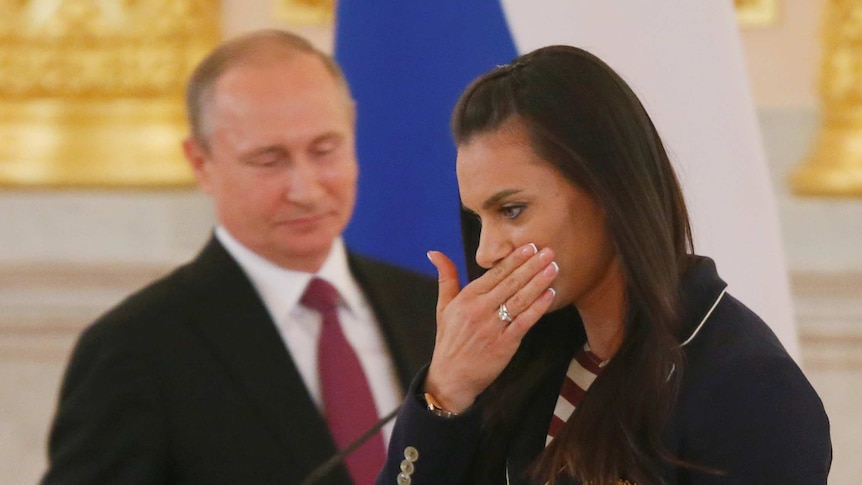 Track-and-field athlete Yelena Isinbayeva reacts as she walks past Russian President Vladimir Putin during his personal send-off for members of the Russian Olympic team