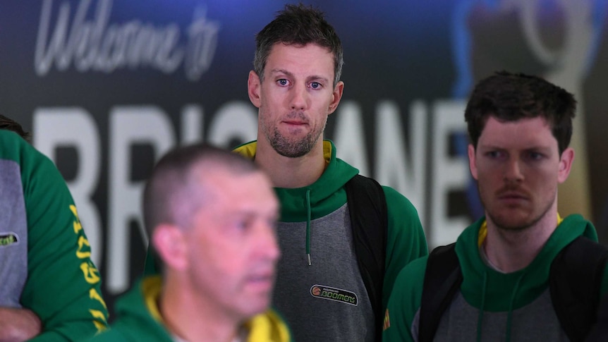 Daniel Kickert of the Boomers (C), listens to coach Andrej Lemanis (L) at Brisbane Airport.