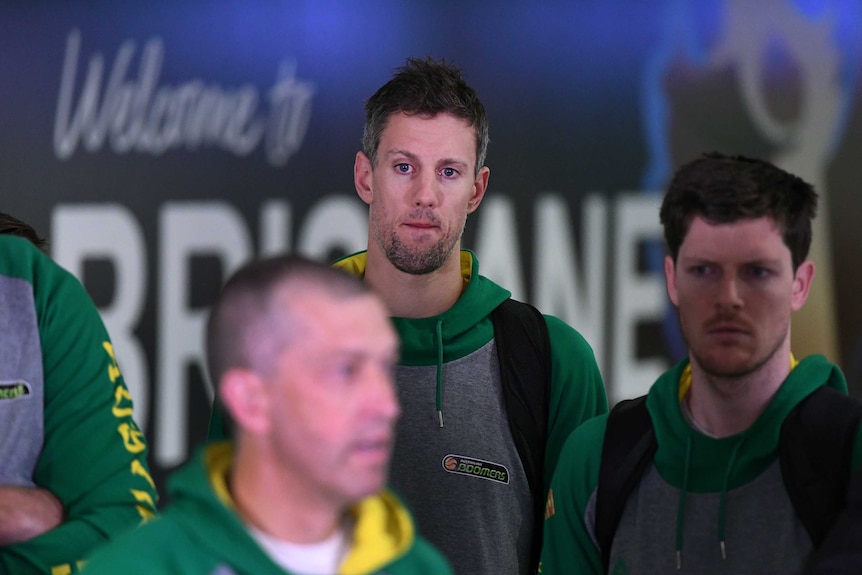 Daniel Kickert of the Boomers (C), listens to coach Andrej Lemanis (L) at Brisbane Airport.