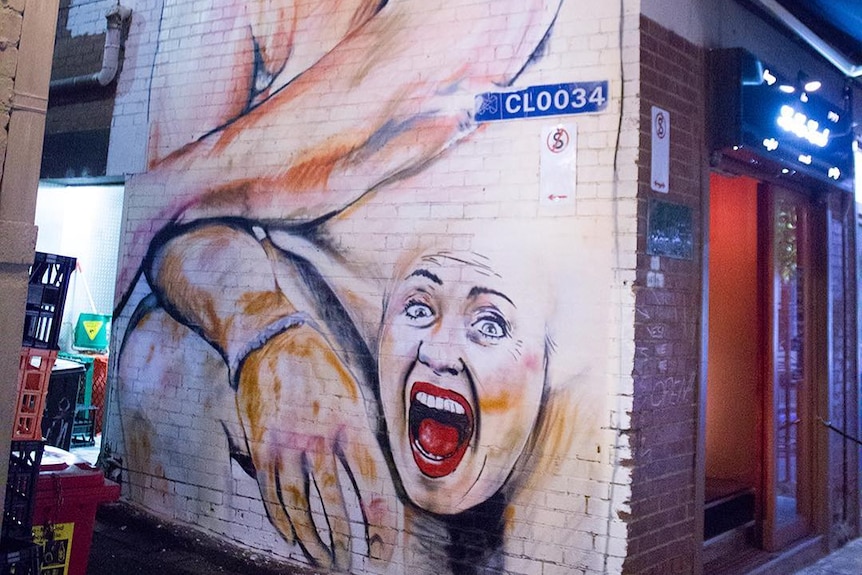Two-story mural of Donald Trump, naked, with Hillary Clinton's face painted over the genitals.