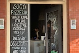 A pizza shop door with its glass smashed in