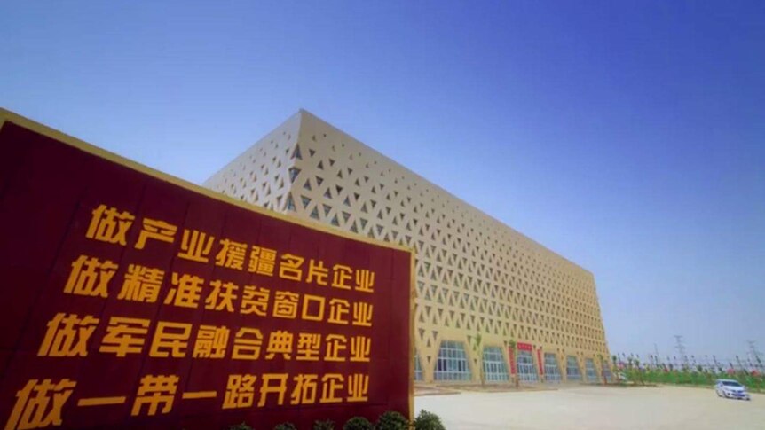 An external shot of Golden Future's factory, from its promo video. It is a cube with triangular windows in a lattice pattern.