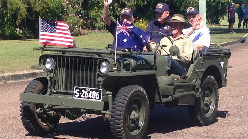 USS Lexington survivor Cecil Wiswell waving from a Jeep.