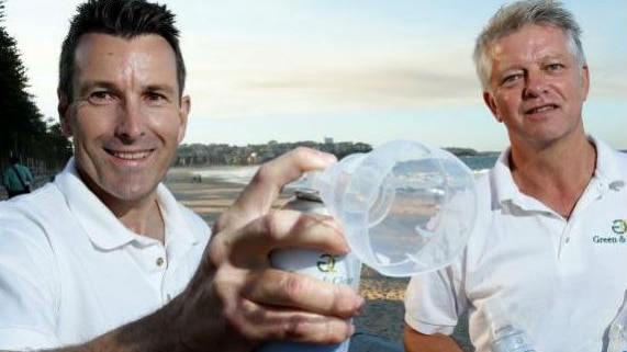 Two men hold an air cannister with a nozzle on it similar to a surgical mask used for breathing