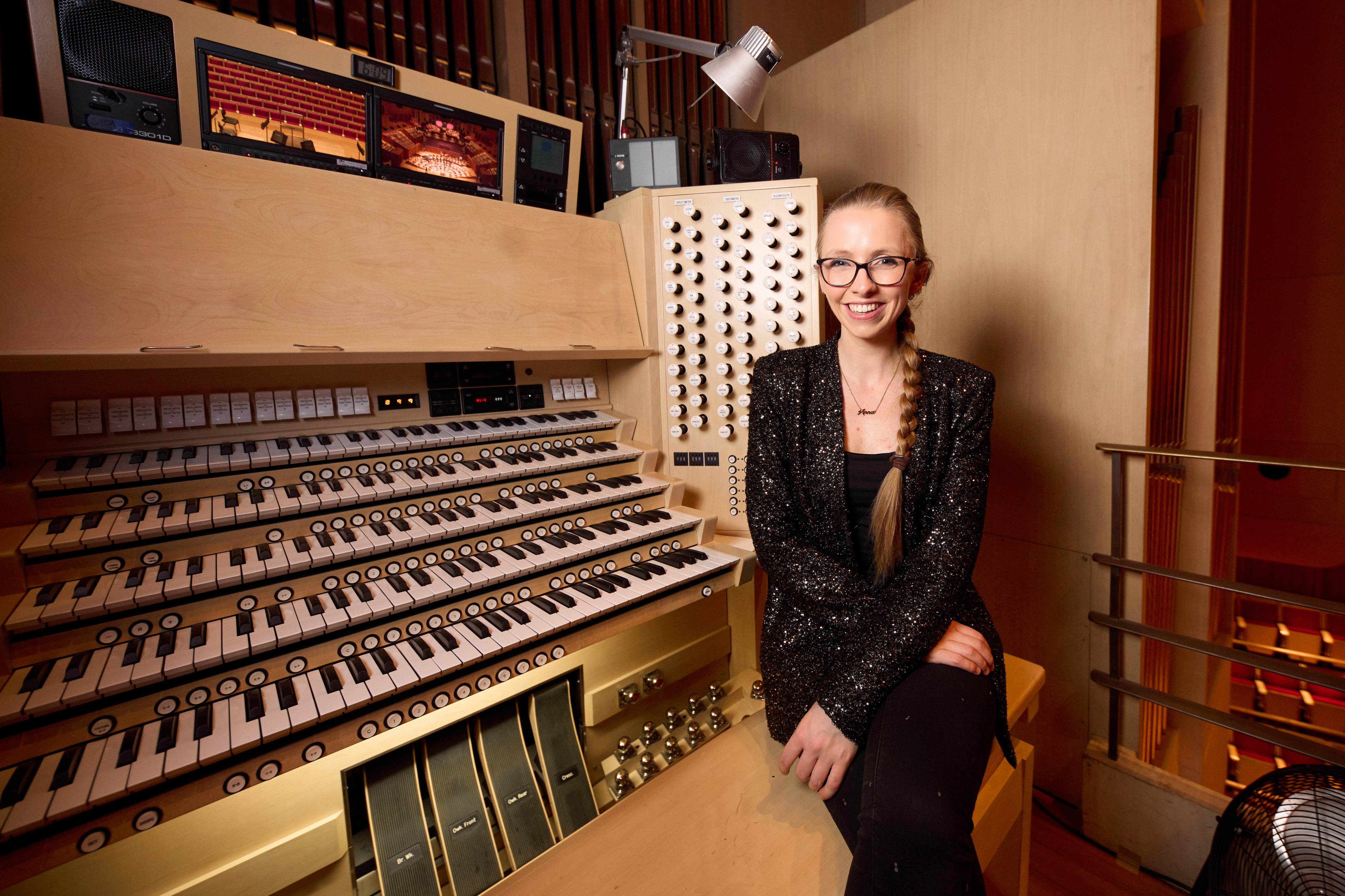 Organist Anna Lapwood sitting in front of the organ console