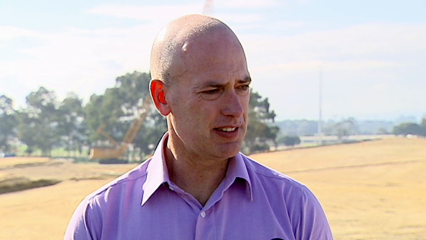 A man standing in front of a paddock.