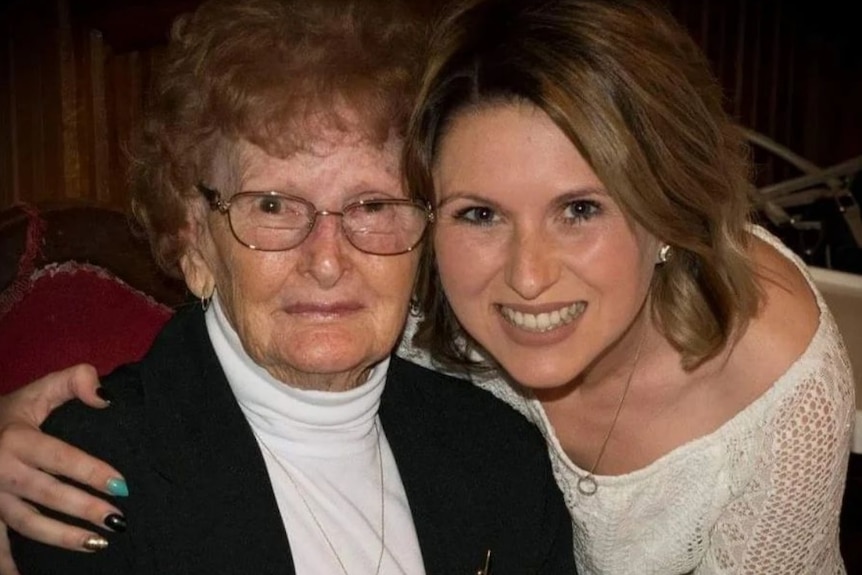 A woman embraces her elderly grandmother.