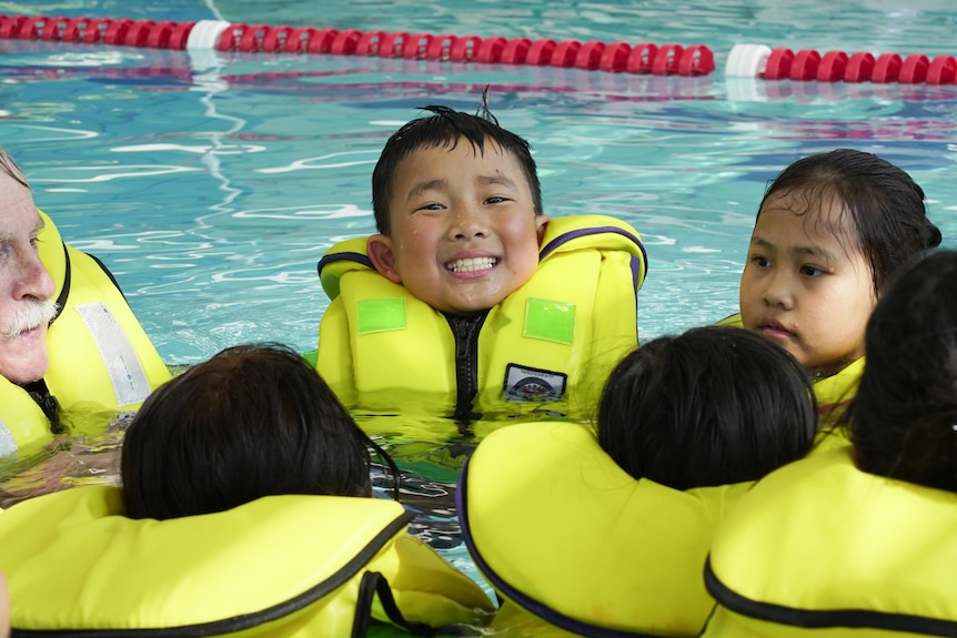 Children in life vests in a pool 