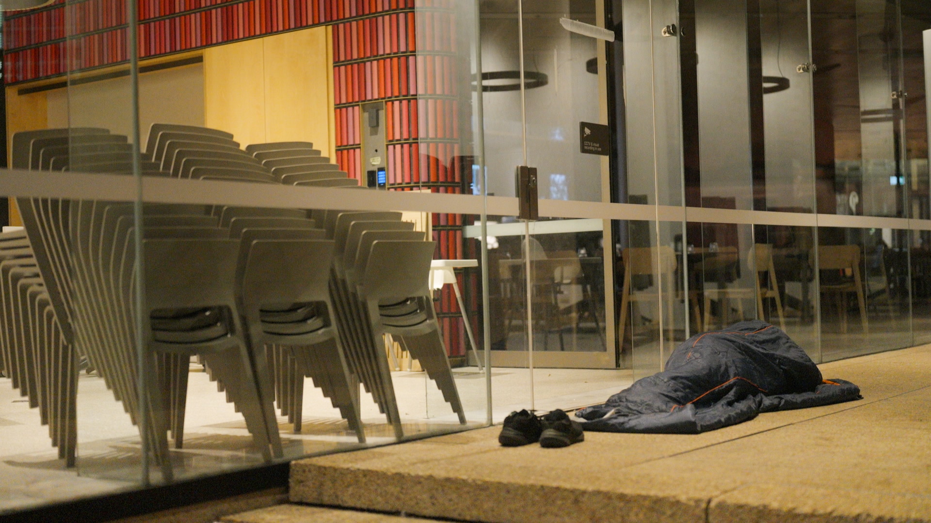 A person in a sleeping bag on a footpath in Sydney