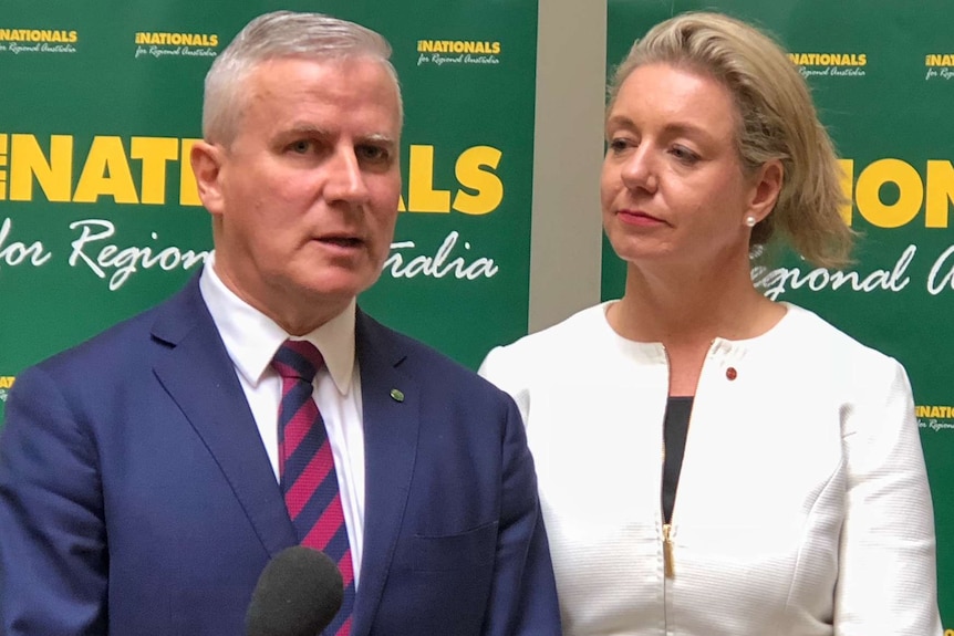 Michael McCormack speaks at a microphone while Bridget McKenzie looks on.