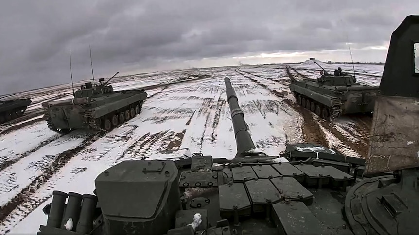 Russian and Belarusian armored vehicles drive in the snow during a joint military drills.
