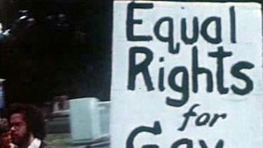 Hands hold up protest sign that reads 'Equal righs for gay teacher'