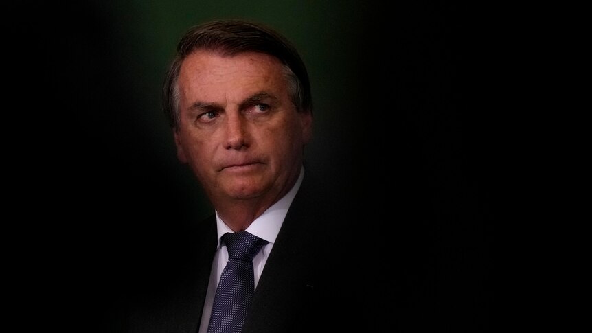 President Jair Bolsonaro with greying hair wearing a black suit and blue tie.