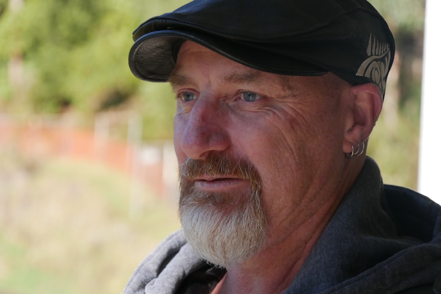 A man wearing a cap looking into the distance. 