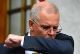 Scott Morrison coughs into his elbow during a press conference at parliament house