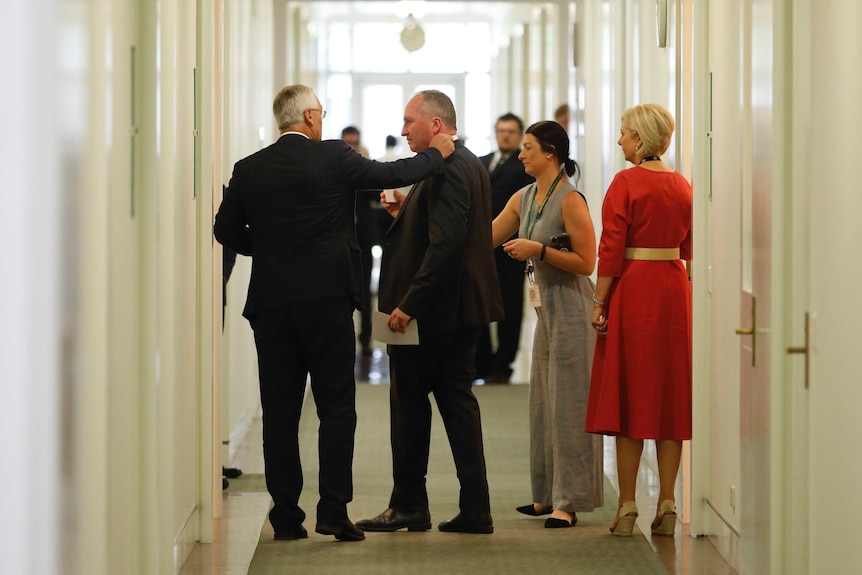 Damian Drum puts his arm on Barnaby Joyce's shoulder as they stand in a corridor