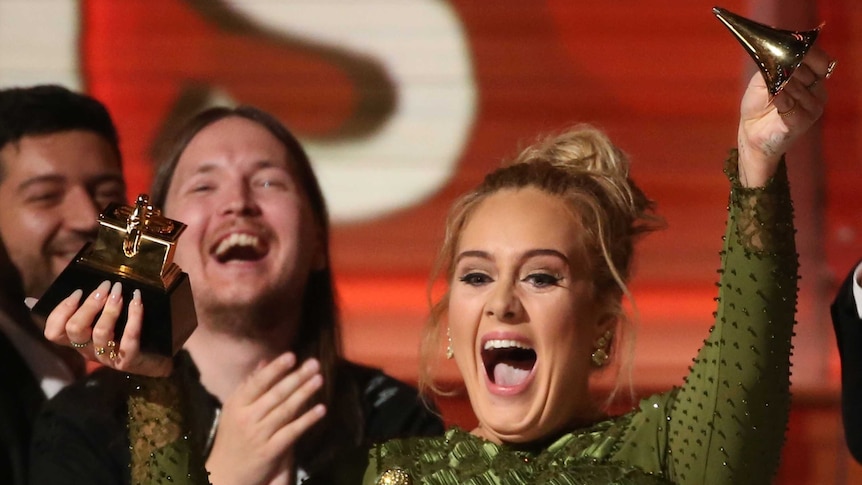 Adele holds up her broken Grammy after winning Record of the Year