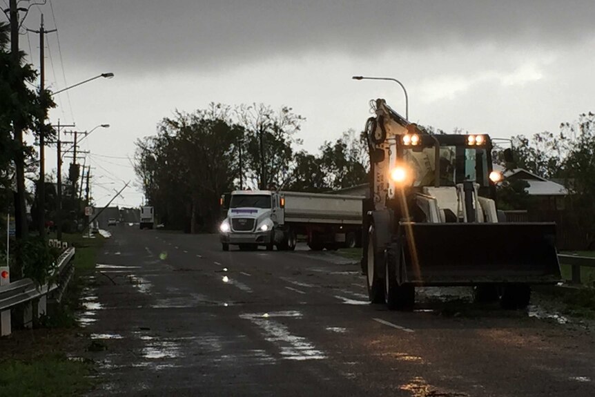 Workers began clearing the roads in Bowen as dark sky looms overhead.