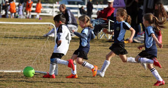 children running around playing soccer