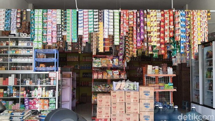 A long shot of kiosk with colourful different products in sachet hanging. 