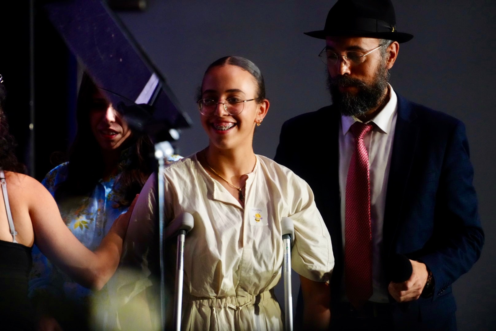 Um adolescente usando muletas no palco.