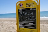 A sign on a beach saying beach closed