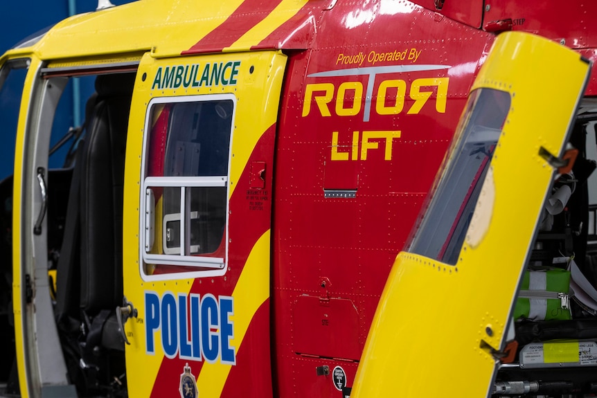 Close up of the side of a red and yellow rescue helicopter