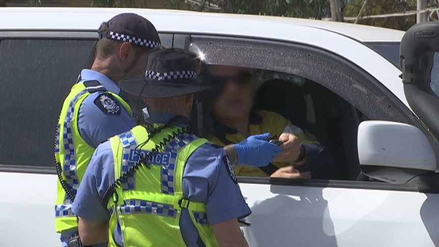 A police officers gather at a regional check point in WA's Goldfields.