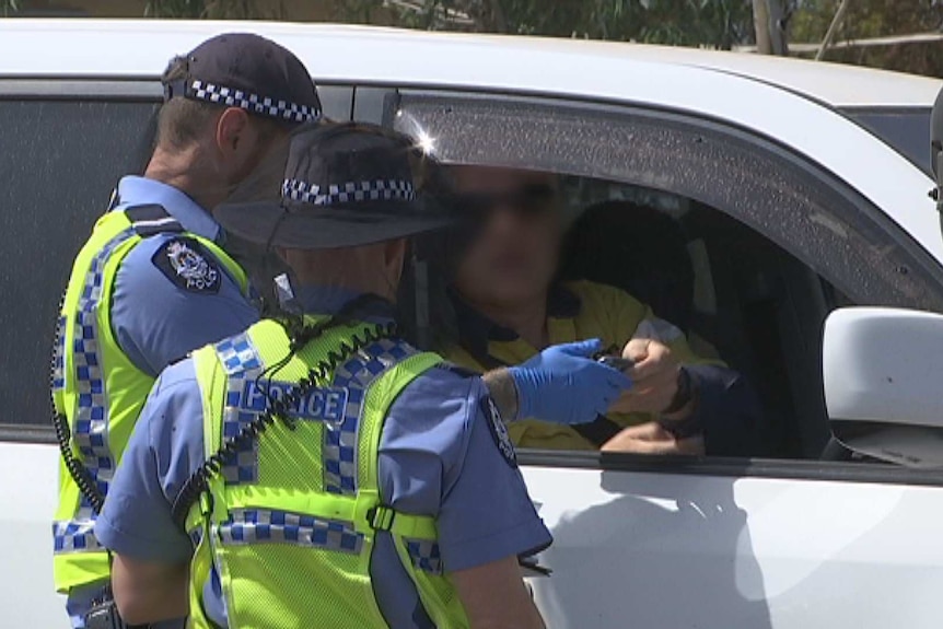 A police officers gather at a regional check point in WA's Goldfields.