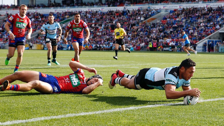 Jesse Ramien dives over to score for the Sharks against the Knights.