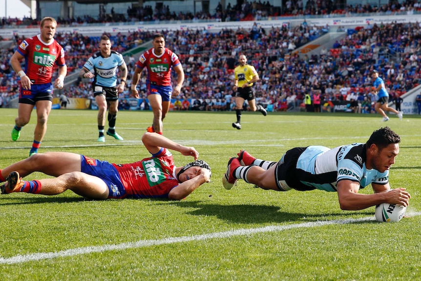 Jesse Ramien dives over to score for the Sharks against the Knights.