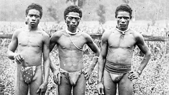 An archival image of South Sea Islanders who were blackbirded to Australia smoking a pipe on a sugar plantation.