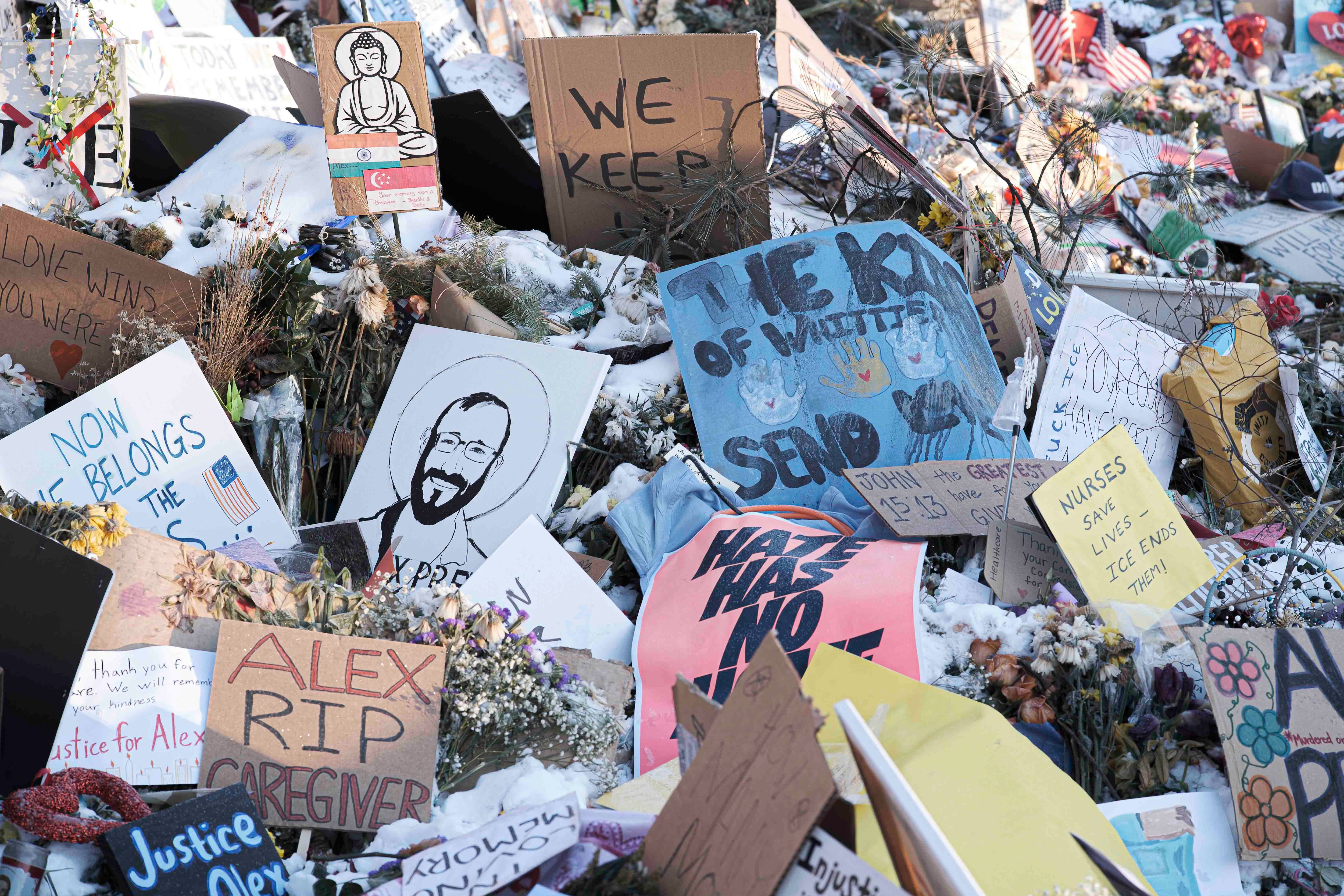 Several cards paying tribute to Alex Pretti at a memorial site.