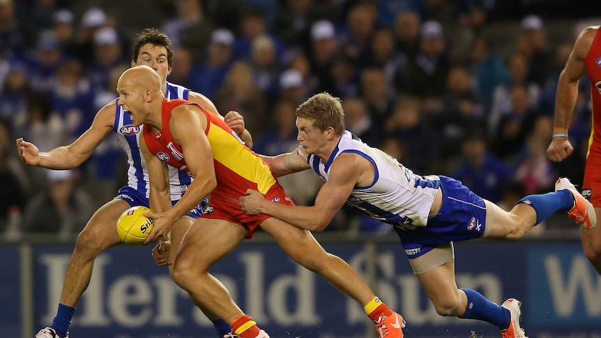 Gold Coast's Gary Ablett is tackled by Jack Ziebell of the Kangaroos at Docklands.