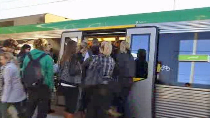Commuters get on a train at a station in Perth.
