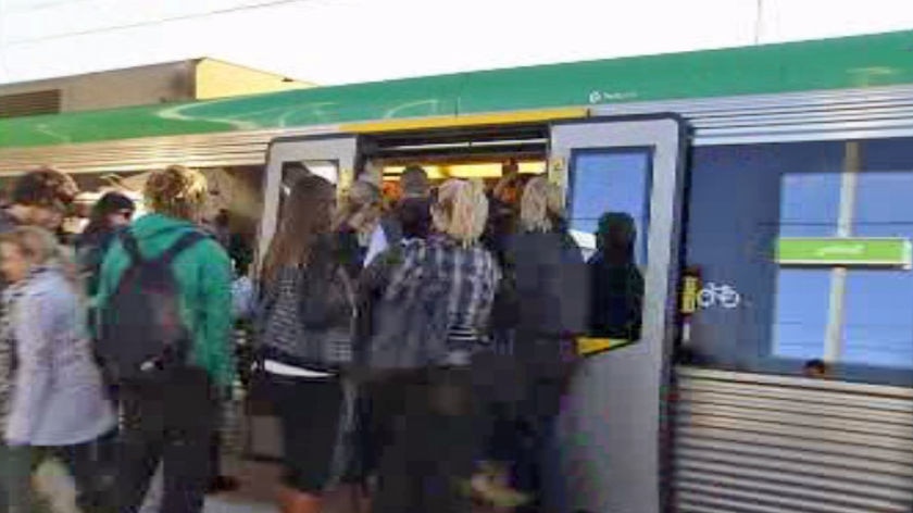 Commuters get on a train at a station in Perth as drivers take strike action