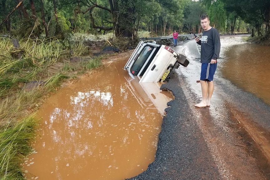A car in a ditch with flood water