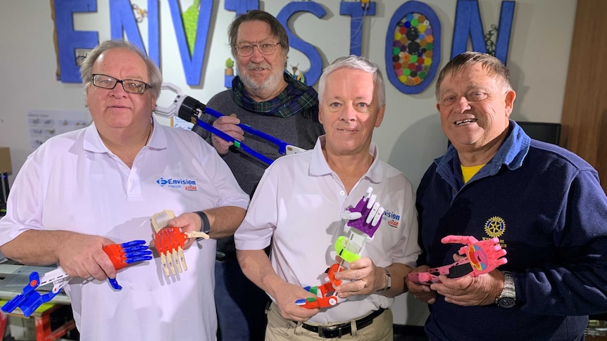 Four men pose with colourful plastic limbs.