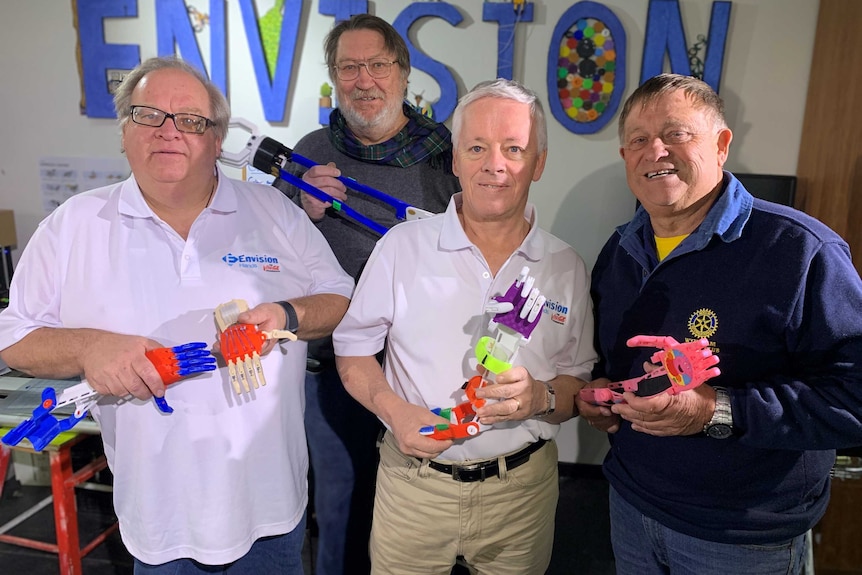 Four men pose with colourful plastic limbs.