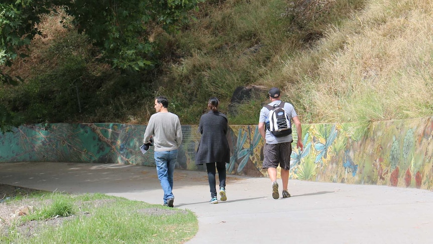 Pete Burns (right) takes two people on a walking tour of Melbourne's inner east.