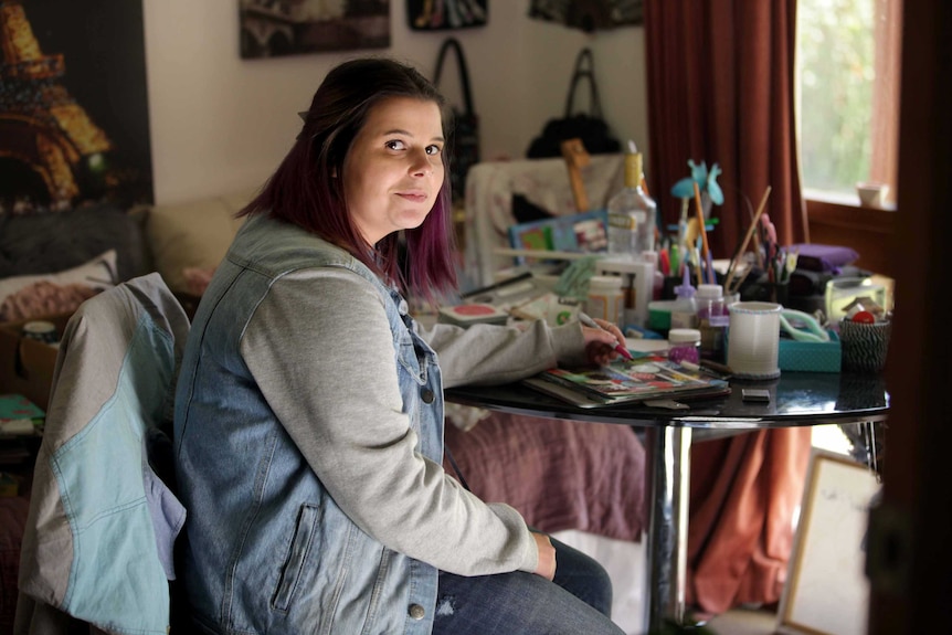 Chantelle Karo is sitting at a crafts table as she looks at the camera.