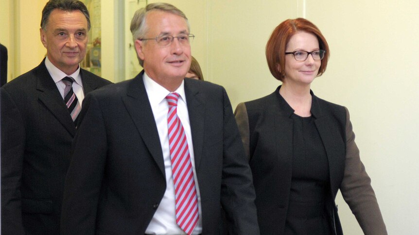Julia Gillard leaves the caucus room with Wayne Swan.