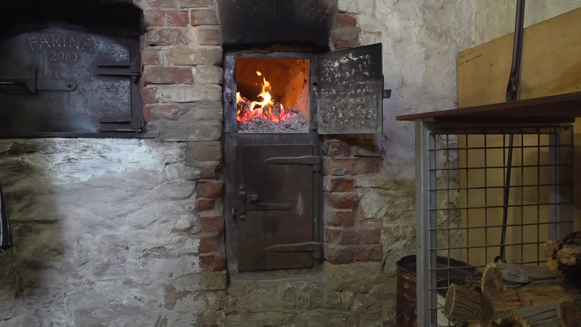A wood-fired oven built into old brick and stone walls.