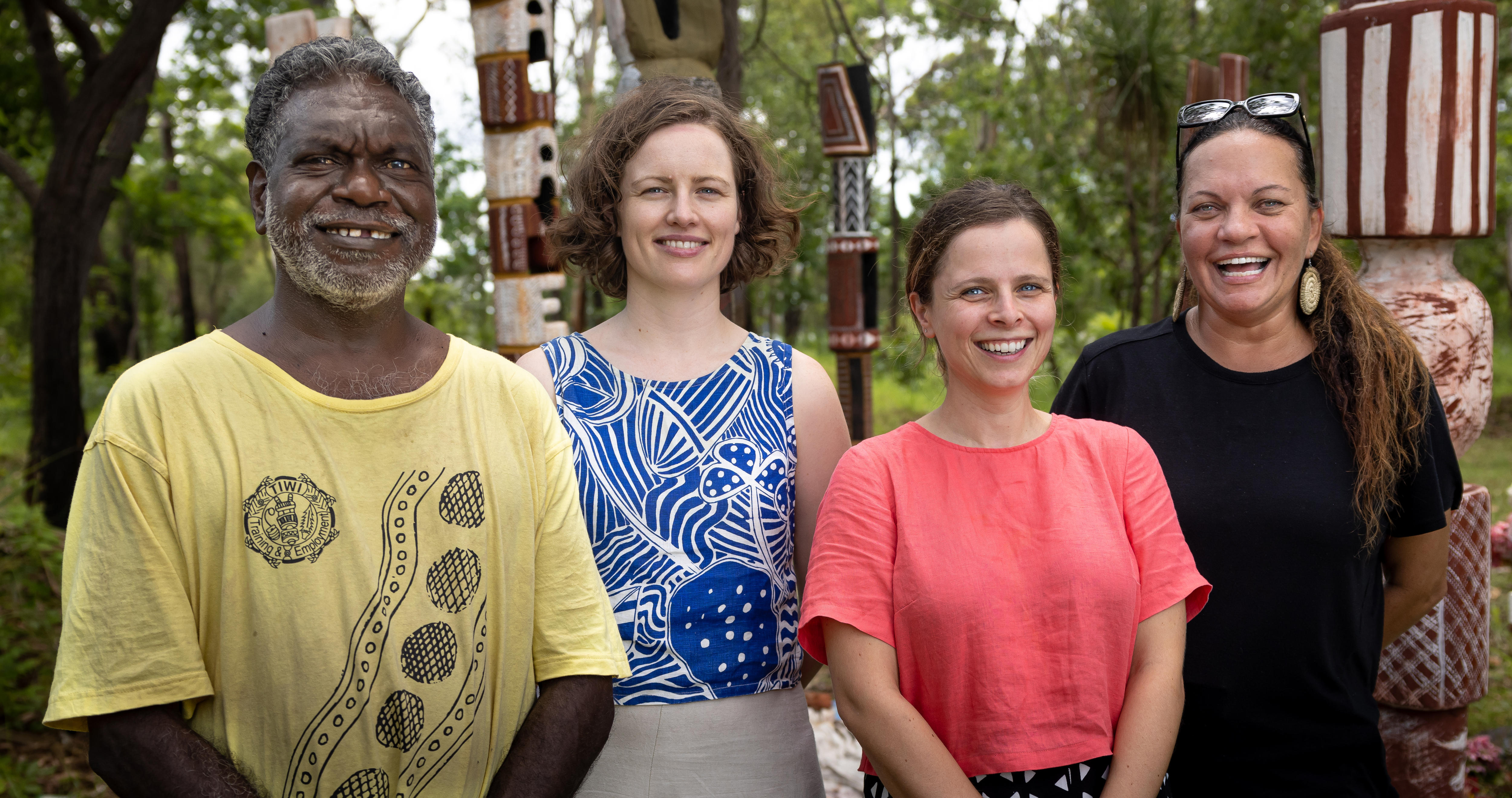 A man and three woman stand together smiling broadly. 